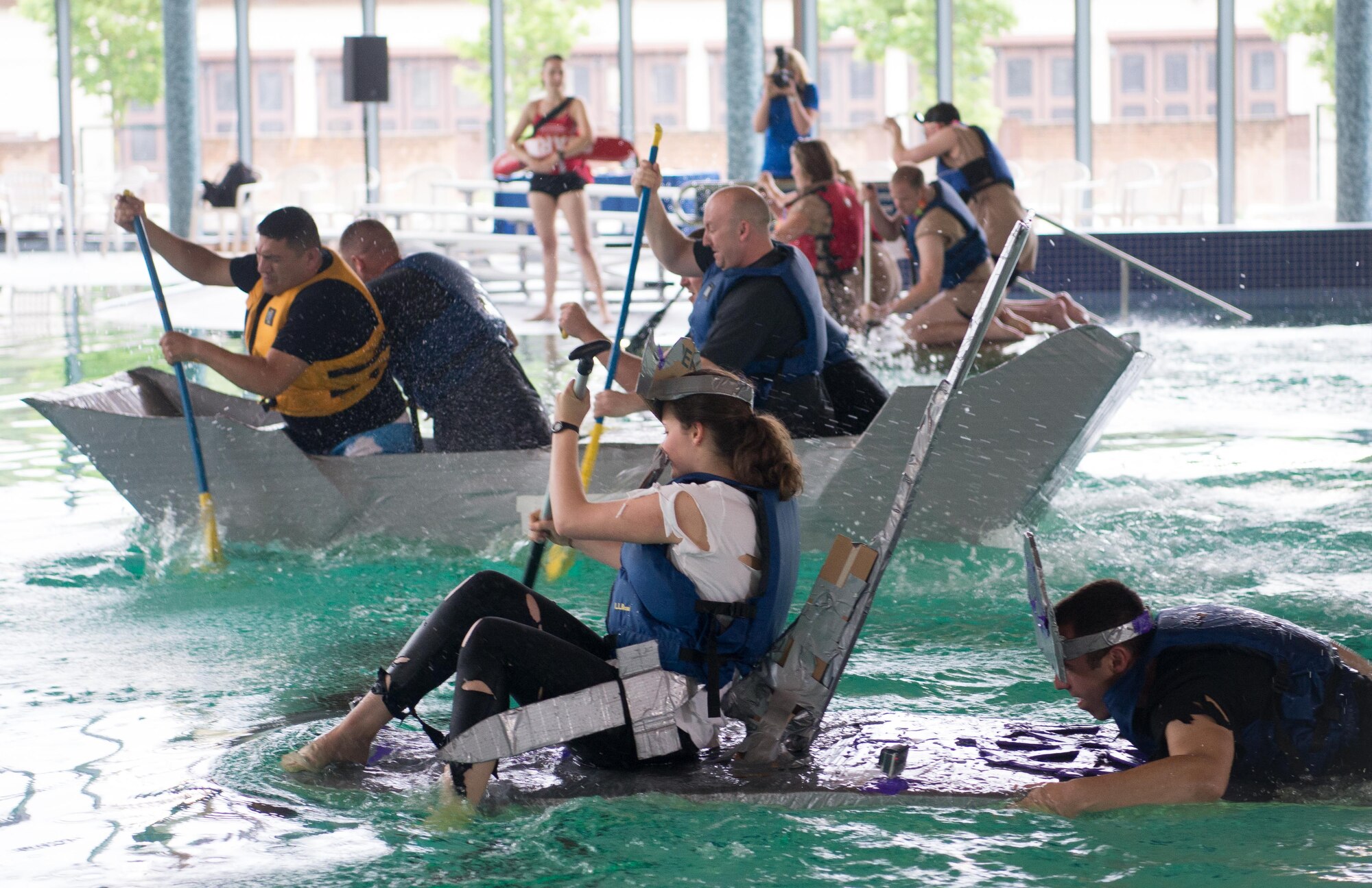 Teams of Airmen assigned to various shops in the Kaiserslautern Military Community area race with their homemade "battleships" during the 86th Force Support Squadron 2017 Battle of the Battleships at the Ramstein Aquatic Center on Ramstein Air Base, May 19, 2017. Teams competed in speed races and a "Last Ship Standing" event for medals and cash prizes during the community and morale event. (U.S. Air Force photo by Senior Airman Elizabeth Baker)