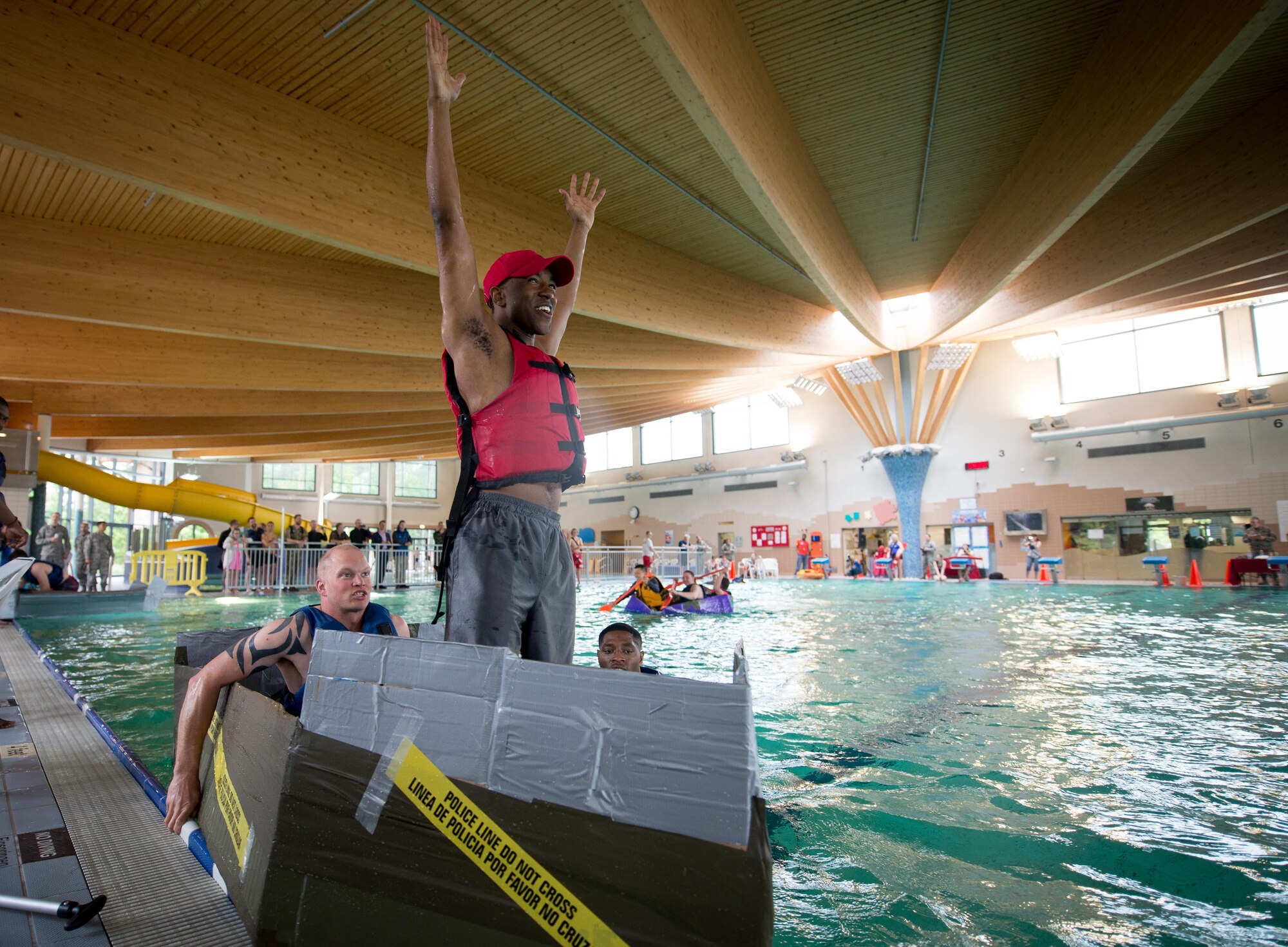 Members of the 86th Security Forces Squadron celebrate finishing the speed race during the 86th Force Support Squadron 2017 Battle of the Battleships on Ramstein Air Base, May 19, 2017. The annual event brings the Kaiserslautern Military Community together to compete with homemade, cardboard-and-duct-tape vessels for medals, cash prizes, and to have the mightiest battleship in the KMC. (U.S. Air Force photo by Senior Airman Elizabeth Baker)