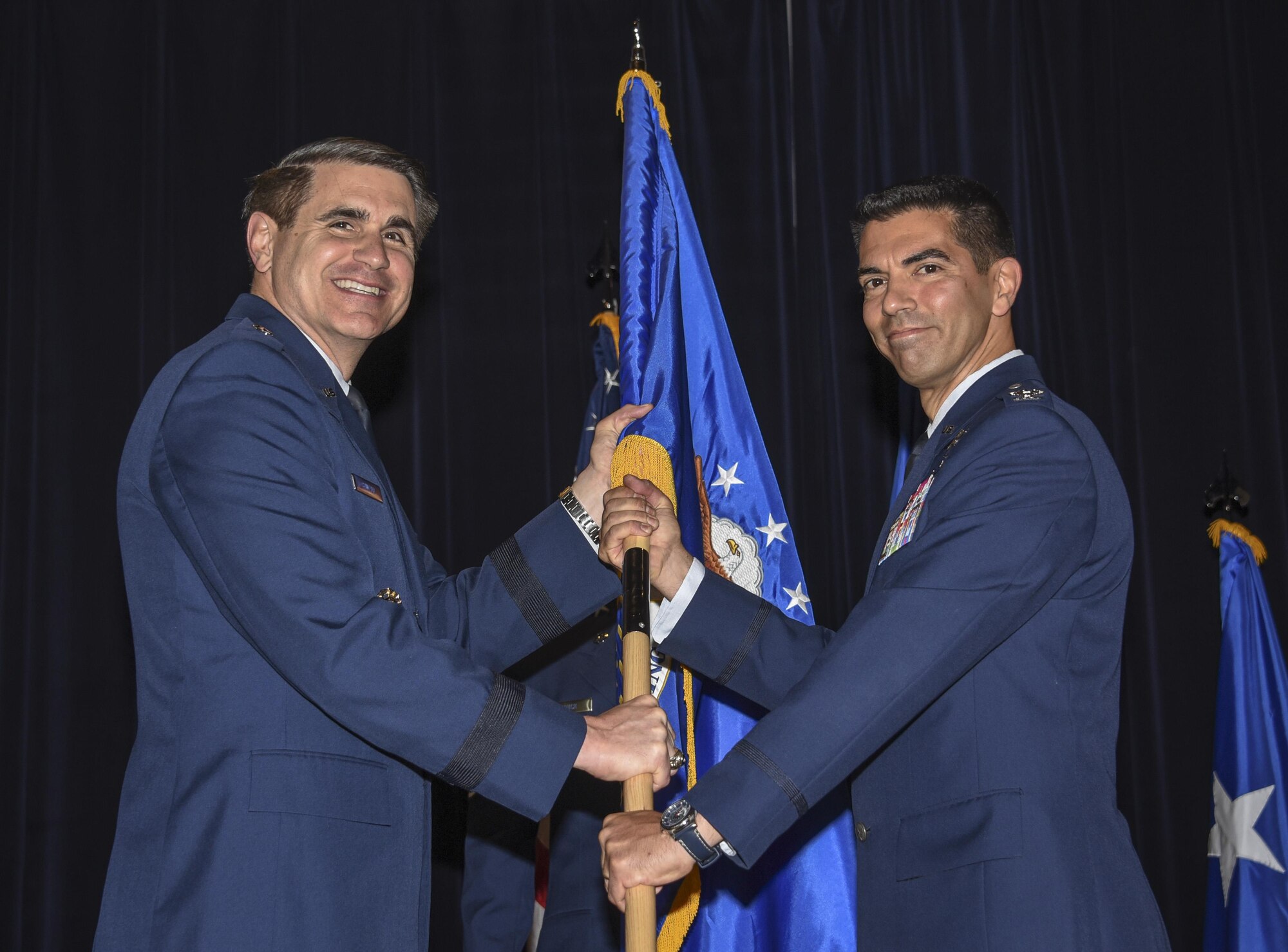 Maj. Gen. B.J. Shwedo, commander, 25th Air Force, passes the 70th Intelligence, Surveillance and Reconnaissance Wing guidon to Col. Matteo Martemucci, during a change of command ceremony May 17 at Fort George G. Meade, Maryland. The passing of the guidon symbolizes Martemucci's assumption of command from the outgoing 70th ISR Wing commander, Col. Thomas Hensley. (U.S. Air Force photo/Staff Sgt. AJ Hyatt)