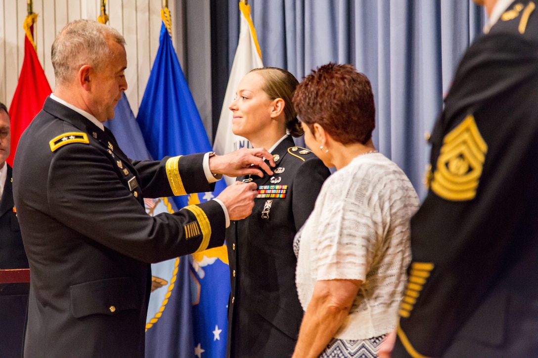 Maj. Gen. Thomas E. Ayres, Deputy Judge Advocate General, awards the Army Commendation Media to Staff Sgt. Sarah Hawley, for earning the Sgt. Eric L. Coggins Award for Excellence. (photo by Lt. Col. Arthur L. Rabin, U.S. Army Reserve Legal Command )