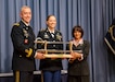 Lori Jenkins, President of JAG Legal Paraprofessionals Association presents a sword to Staff Sgt. Sarah Hawley. Hawley was presented with the Sgt. Eric L. Coggins Award for Excellence at a ceremony on May 16, 2017, at The Judge Advocate General’s Legal Center and School, in Charlottesville, VA.  (Photo by Lt. Col. Arthur L. Rabin, U.S. Army Reserve Legal Command )