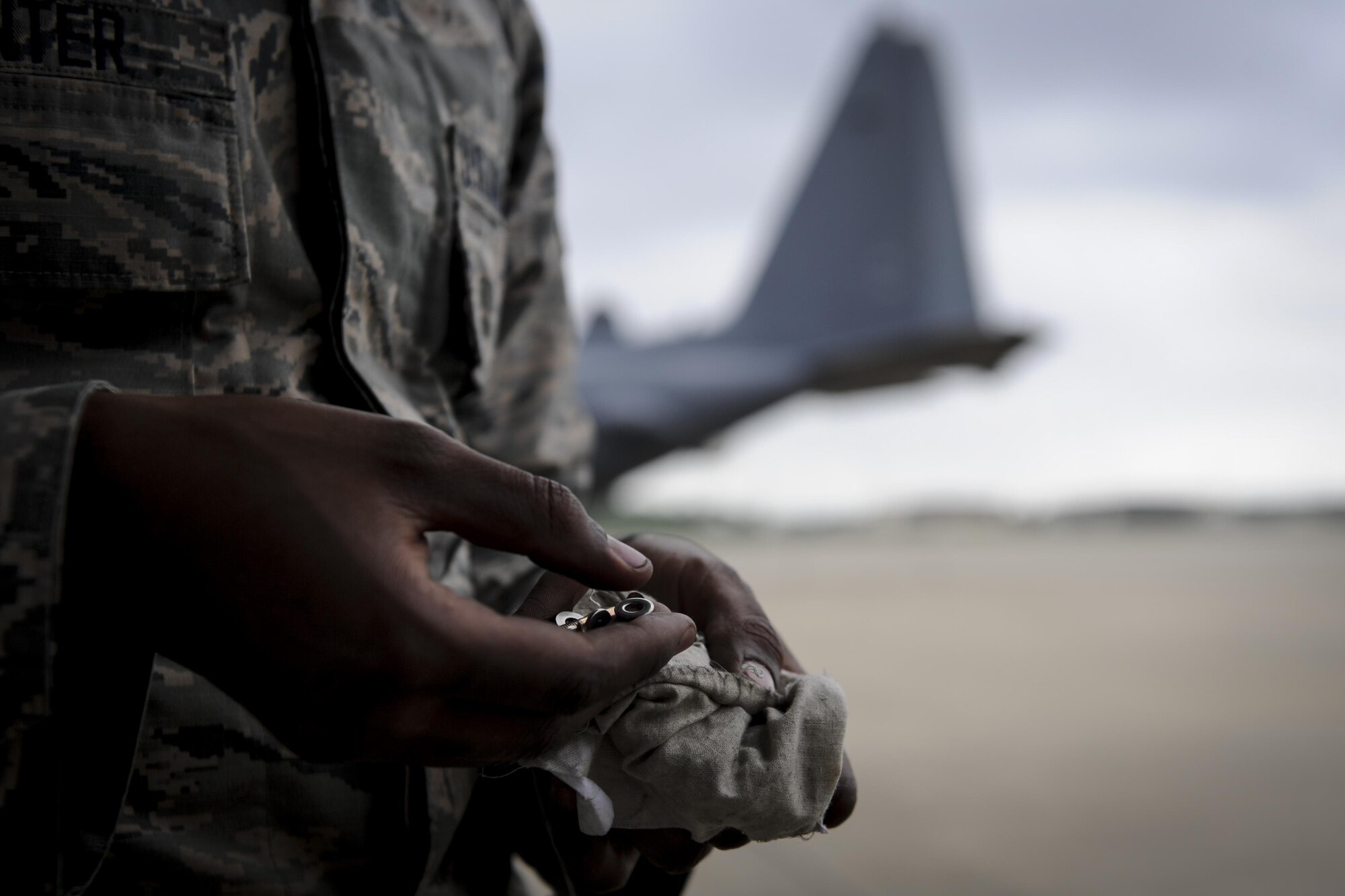 Airman 1st Class Anthony Hunter, a crew chief with the 4th Aircraft Maintenance Unit, removes screws from a small pouch at Hurlburt Field, Fla., May 19, 2017. Hunter helped install a new flat baffle to an AC-130U Spooky gunship. This part is installed on the wings of the aircraft and is replaced as needed. (U.S. Air Force photo by Airman 1st Class Dennis Spain)