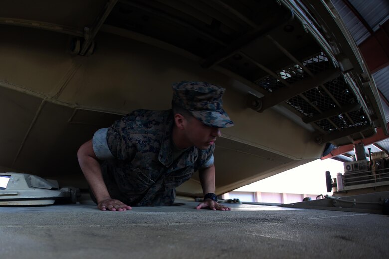 Lance Cpl. Cyrus Obregon climbs through the driver’s hole of an M1A1 Abrams tank during a field trip at Marine Corps Base Camp Lejeune, N.C., May 16, 2017. Marines assigned to the Marine Corps Air Station Cherry Point Squadron Intelligence Training Certification Course had the opportunity to visit various units stationed at MCB Camp Lejeune, N.C. and MCAS New River, N.C., in order to provide them a better understanding about capabilities and limitations of aircraft, weapons systems and vehicles their units may utilize. Obregon is a student assigned to the MCAS Cherry Point SITCC program. (U.S. Marine Corps photo by Cpl. Mackenzie Gibson/Released)