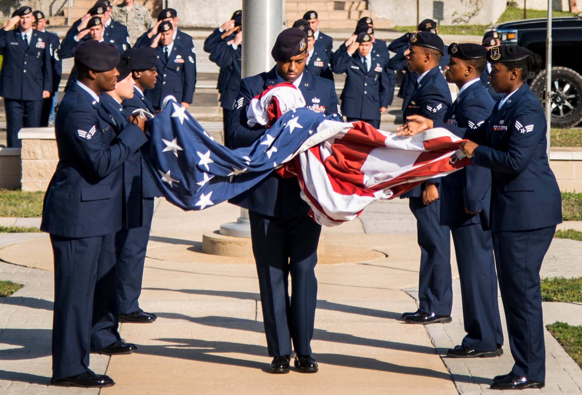 Staff Sgt. Keith Miller, 96th Security Forces Squadron, unfurls the base flag as a formation salutes during the base retreat ceremony May 19 at Eglin Air Force Base, Fla.  The retreat ceremony closed out the base’s Police Week activities.  (U.S. Air Force photo/Cheryl Sawyers)