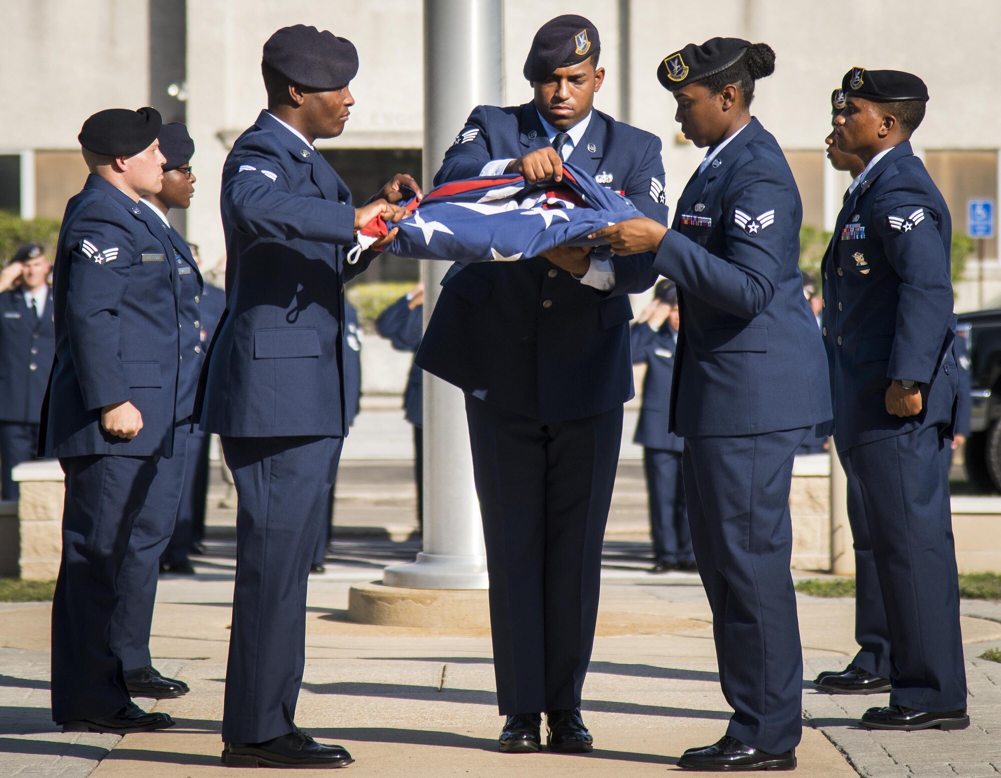 Staff Sgt. Keith Miller, 96th Security Forces Squadron, secures the American Flag during the base retreat ceremony May 19 at Eglin Air Force Base, Fla.  The retreat ceremony closed out the base’s Police Week activities.  (U.S. Air Force photo/Cheryl Sawyers)