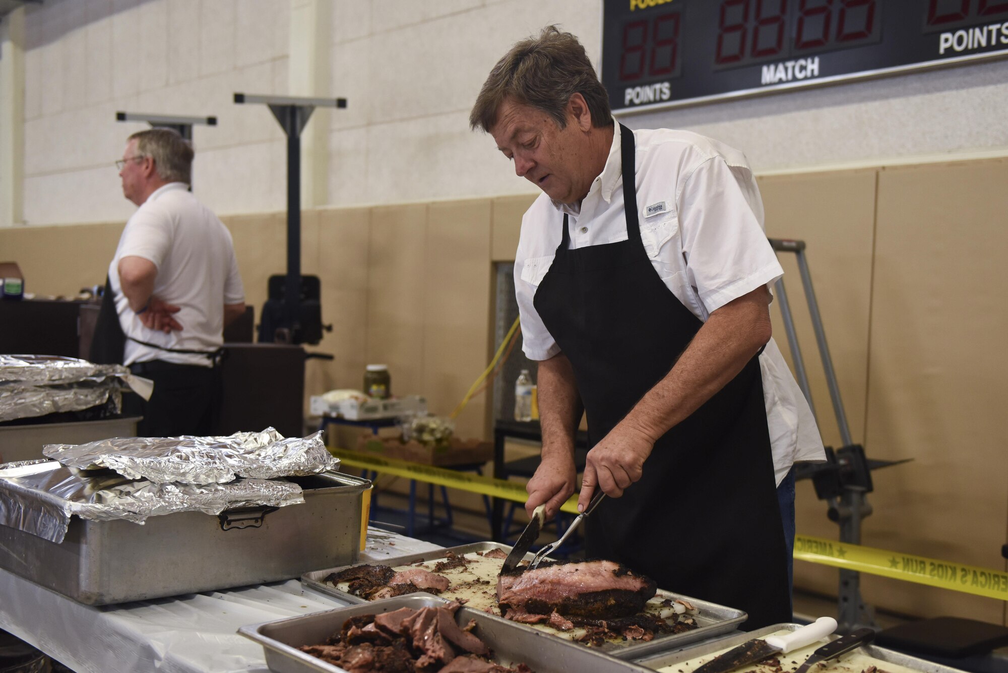 Brisket is prepared by volunteers at the Carswell Field House on Goodfellow Air Force Base, Texas, May 20, 2017. Food and admission were offered free to all Team Goodfellow members. (U.S. Air Force photo by Airman 1st Class Chase Sousa/Released)