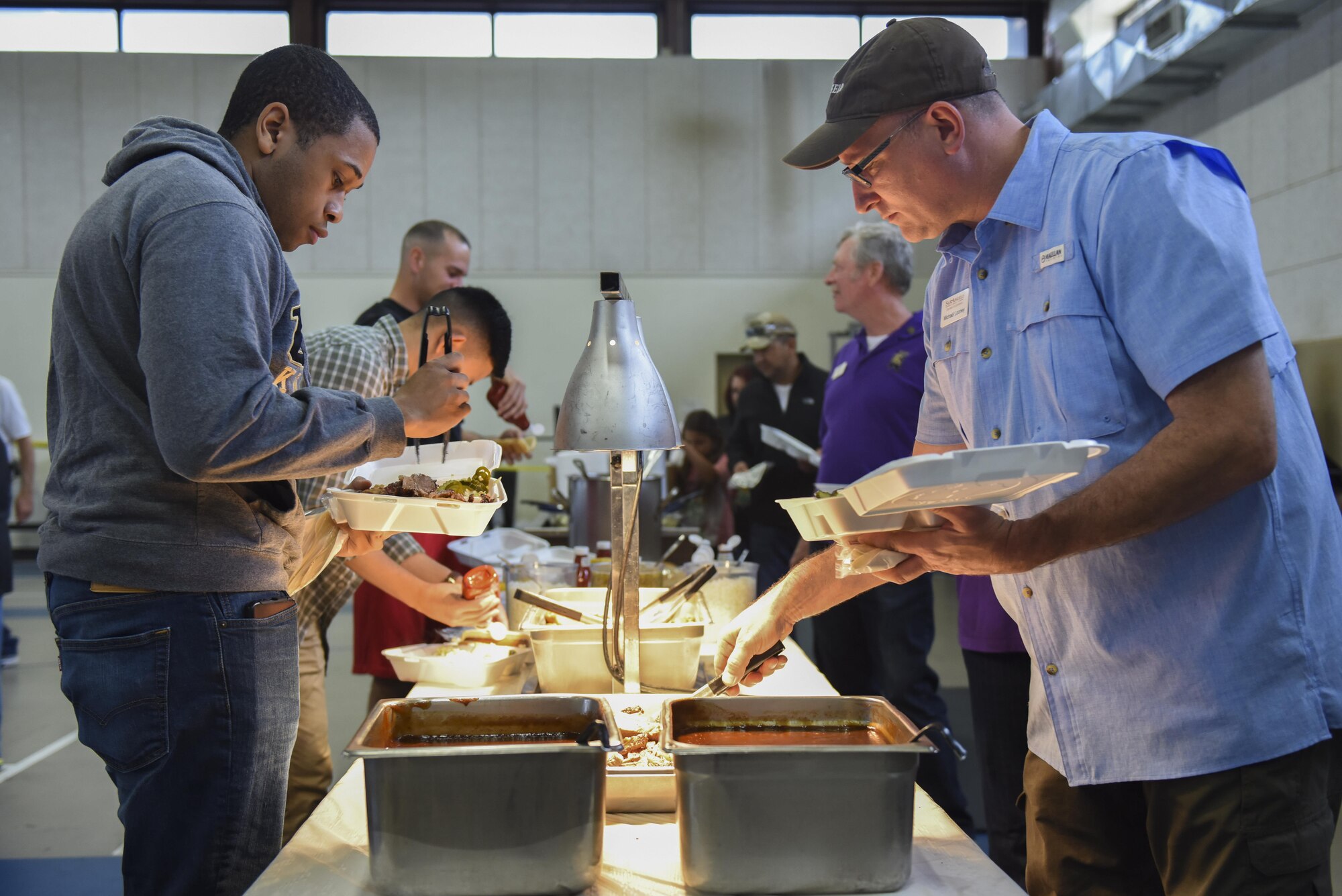 Goodfellow members and San Angelo residents plate their meals at the Goodfellow Appreciation Day at the Carswell Field House on Goodfellow Air Force Base, Texas, May 20, 2017. The event was sponsored by the city of San Angelo to show appreciation for Goodfellow and Goodfellow members. (U.S. Air Force photo by Airman 1st Class Chase Sousa/Released)
