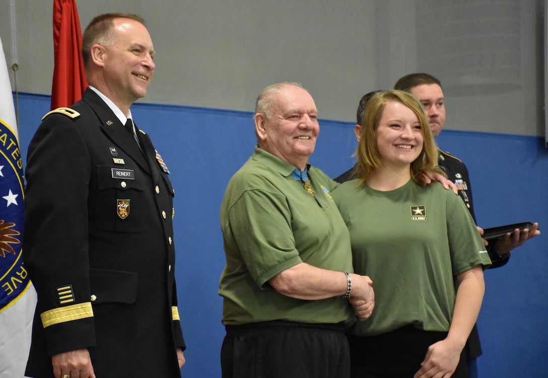 Mikaila Falash receives an "Our Community Salutes" certificate from Medal of Honor recipient Command Sergeant Major (Ret.) Kenneth E. Stumpf and Fort McCoy Senior Commander and 88th Regional Support Command Commanding General, Maj. Gen. Patrick Reinert during an “Our Community Salutes” event at Fort McCoy, Wisconsin on Armed Forces Day, May 20, to recognize and honor graduating high school seniors who have committed to enlist in the Armed Forces following high school graduation.