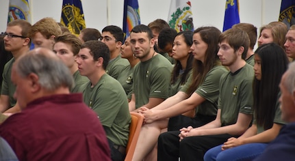 Graduating high school seniors who have committed to enlist in the Armed Forces following high school graduation listen to guest speakers during an “Our Community Salutes” event at Fort McCoy, Wisconsin on Armed Forces Day, May 20, 2017.