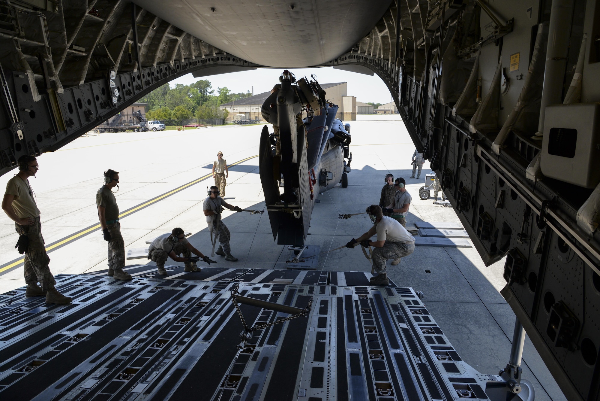 Members of the 723d Aircraft Maintenance Squadron, 41st Helicopter Maintenance Unit assigned to Moody Air Force Base, Ga., guide an HH-60G Pave Hawk search and rescue helicopter onto a 3d Airlift Squadron C-17 Globemaster III May 15, 2017, at Moody AFB. Airmen applied constant pressure on the towlines to direct the helicopter and also ensure the winch maintained tension. (U.S. Air Force photo by Senior Airman Aaron J. Jenne)