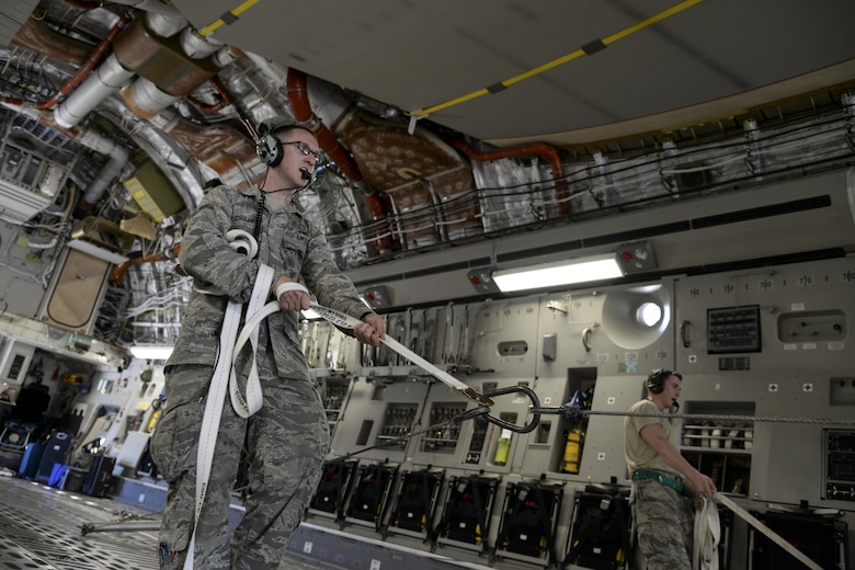 Airman 1st Class Isaac Schuler, 723d Aircraft Maintenance Squadron, 41st Helicopter Maintenance Unit electronic warfare technician assigned to Moody Air Force Base, Ga., guides an HH-60G Pave Hawk search and rescue helicopter May 16, 2017, as it is offloaded from a 3d Airlift Squadron C-17 Globemaster III at Langley Air Force Base, Va. The Airmen worked in unison to ensure the helicopter was safely off-loaded. (U.S. Air Force photo by Senior Airman Aaron J. Jenne)
