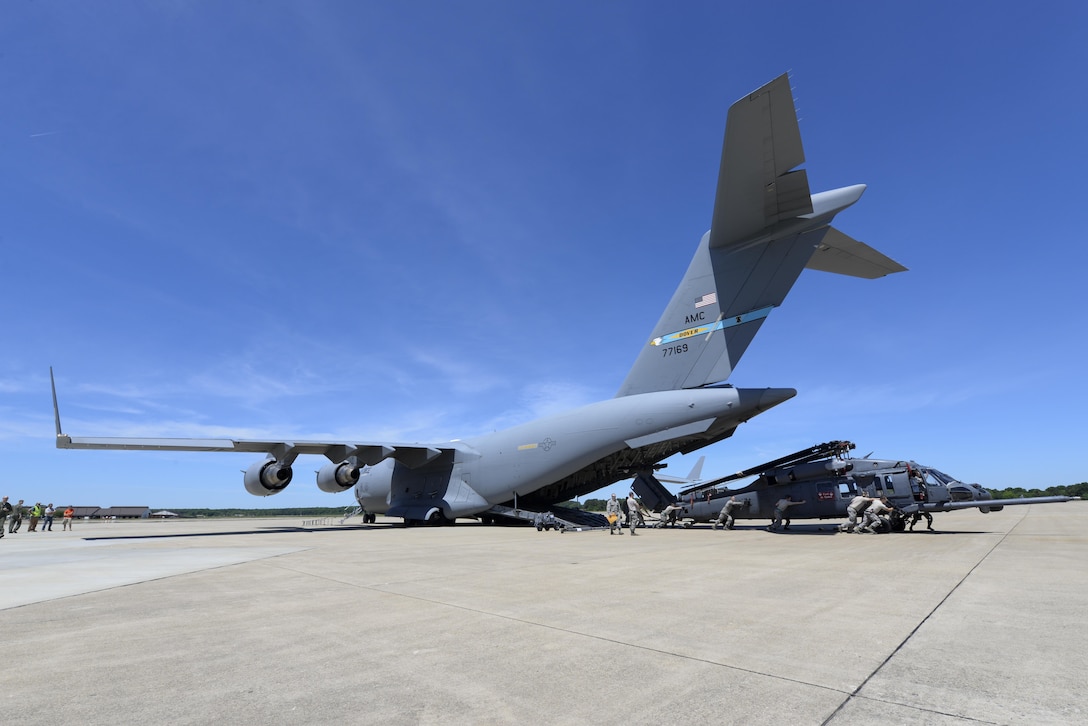 One of Team Dover’s C-17 Globemaster IIIs sets on the flightline as an HH-60G Pave Hawk search and rescue helicopter is offloaded May 16, 2017, at Langley Air Force Base, Va. The C-17 transported 2 helicopters and 40 Airmen from Moody AFB, Ga., to Langley AFB where they participated in Exercise RAPID RESCUE. (U.S. Air Force photo by Senior Airman Aaron J. Jenne)