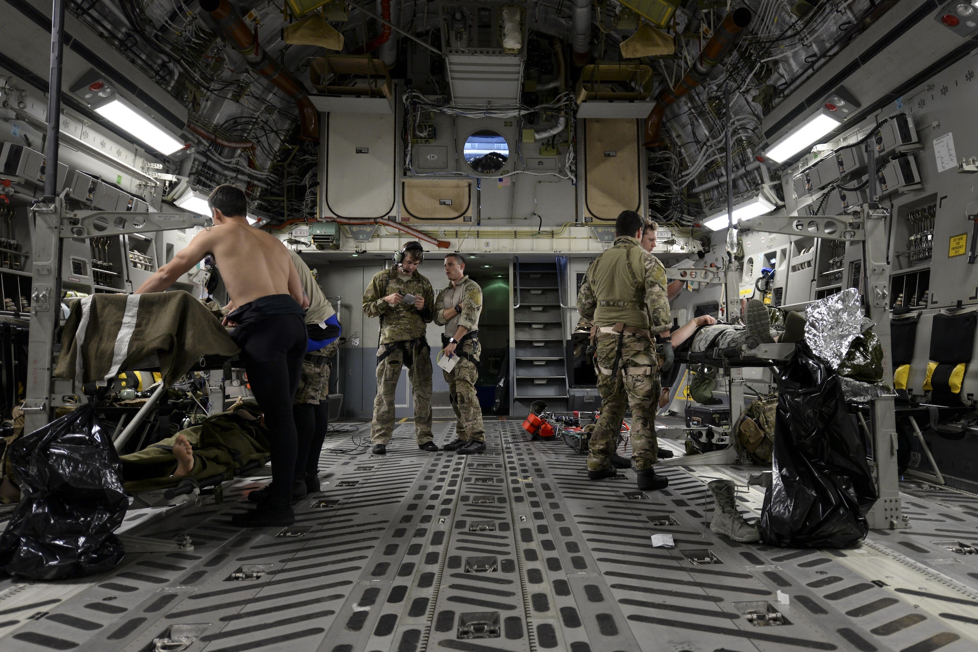 A team of pararescuemen assigned to the 38th Rescue Squadron, Moody Air Force Base, Ga., tend to the simulated injuries of three Airmen May 17, 2017, during Exercise RAPID RESCUE aboard a 3d Airlift Squadron C-17 flying over the coast of Va. When deployed, pararescuemen routinely support aeromedical evacuations aboard cargo aircraft. (U.S. Air Force photo by Senior Airman Aaron J. Jenne)
