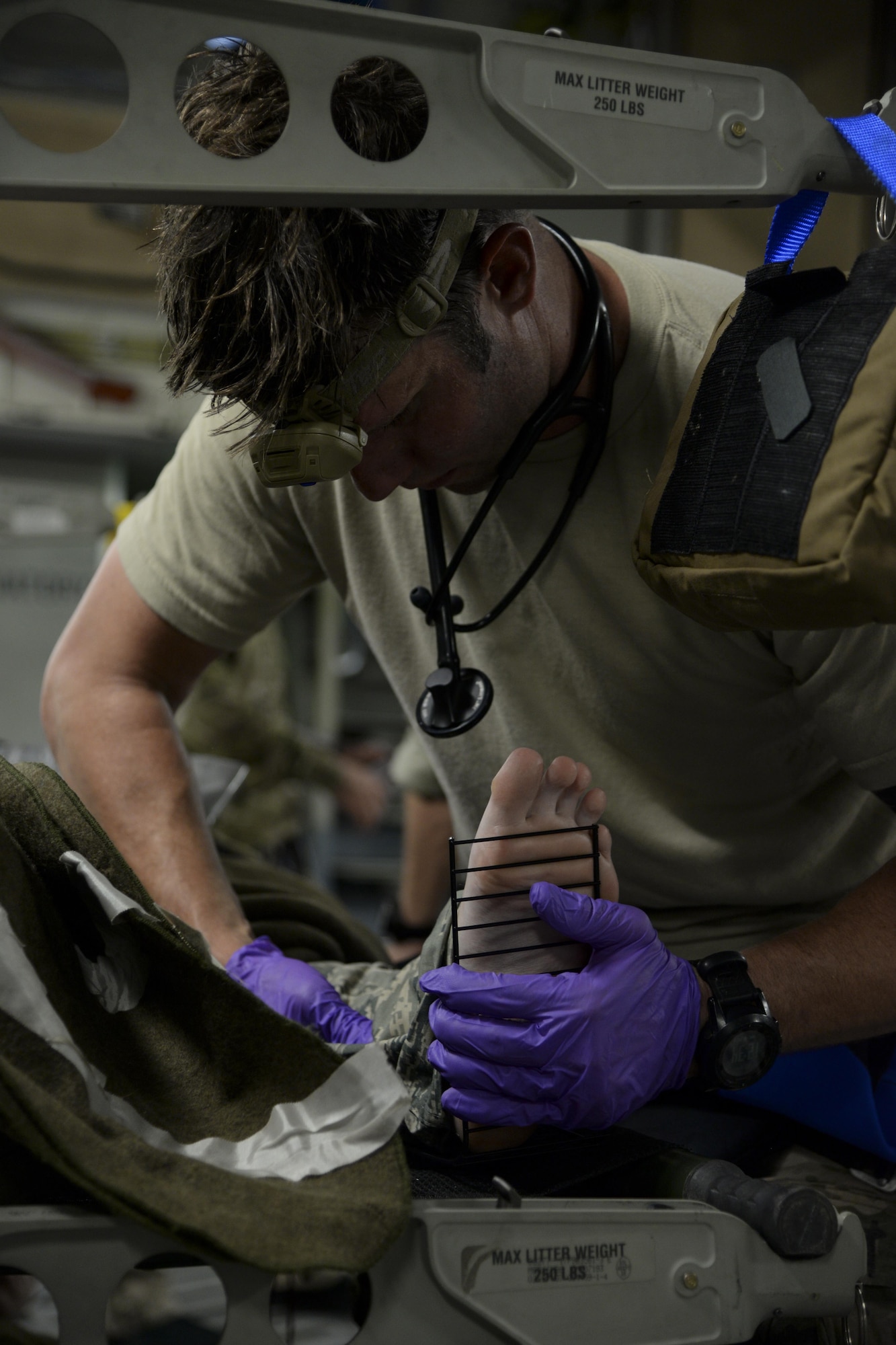 Staff Sgt. Travis Lester, 38th Rescue Squadron pararescueman assigned to Moody Air Force Base, Ga., fits a splint to a simulated injured leg May 17, 2017, during Exercise RAPID RESCUE aboard a 3d Airlift Squadron C-17 Globemaster III. The pararescuemen utilized several medical techniques to immobilize, sanitize and control simulated injuries during the aeromedical evacuation. (U.S. Air Force photo by Senior Airman Aaron J. Jenne)