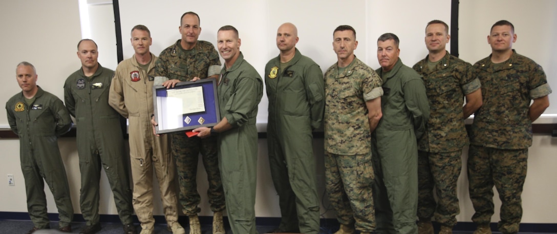 Maj. Gen. Daniel O’Donohue, fourth from left, 1st Marine division commanding general, awards Col. Michael Borgschulte, fifth from left, commanding officer of Marine Aircraft Group (MAG) 39, and the MAG-39 squadron commanding officers, a certificate of honorary membership at Marine Corps Air Station Camp Pendleton, Calif., May 15. 1st MARDIV recognized MAG-39 as an honorary member for continuing to support I MEF ground Marines and continuously working toward more advanced Marine air-ground task force integration. (U.S. Marine Corps photo by Lance Cpl. Jake M.T. McClung/Released)