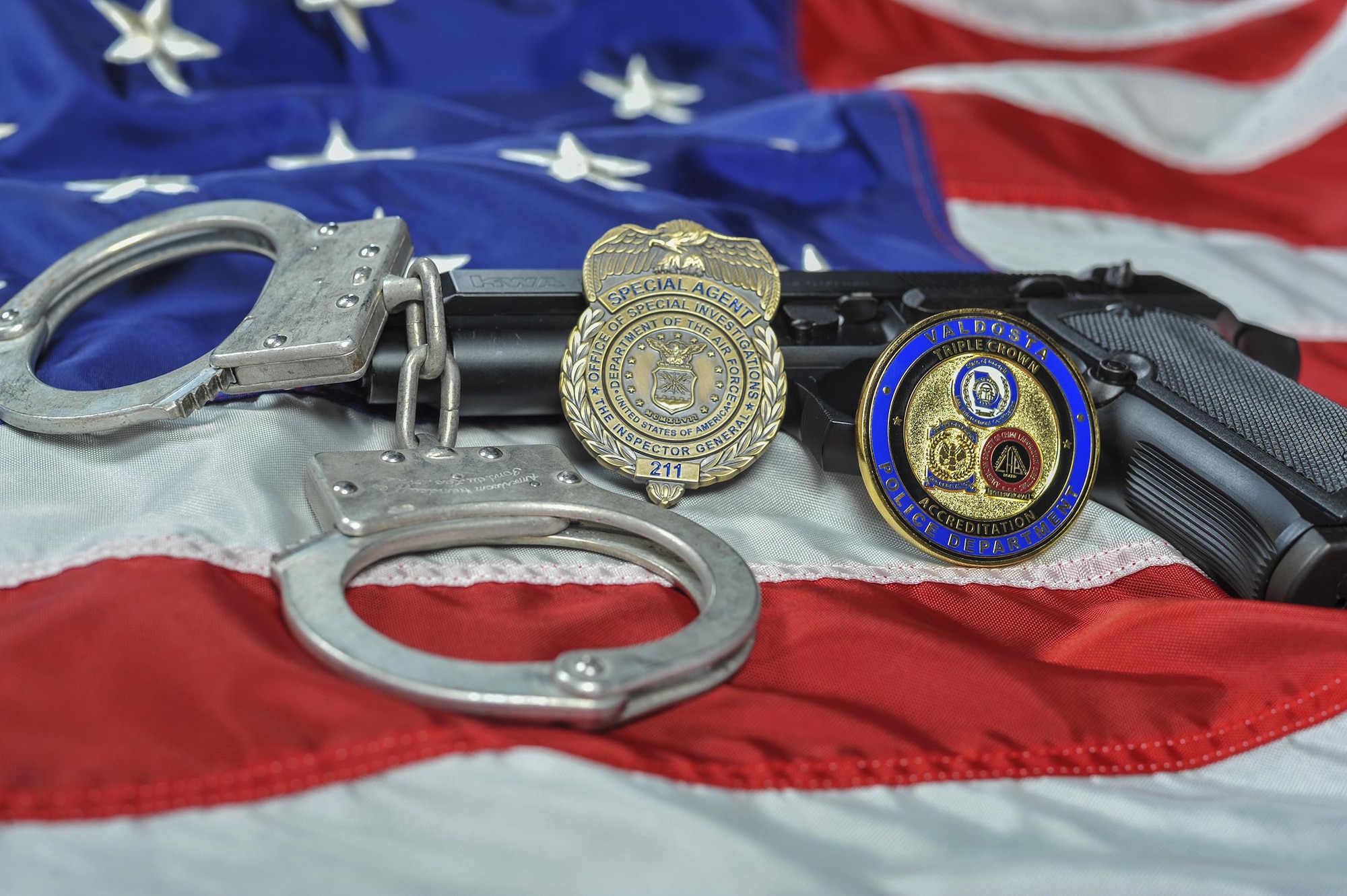 Moody’s Air Force Office of Special Investigations Detachment 211 and Valdosta Police Department badges rest on display, May 22, 2017, at Moody Air Force Base, Ga. Moody’s AFOSI and local law enforcement agencies rely on each other to help promote drug-free, non-addictive lifestyles within both on and off base communities. Since AFOSI is most interested in combating distribution and manufacturing of controlled substances, they rely on local law local enforcement to lend a hand.  (U.S. Air Force photo by Senior Airman Greg Nash) 