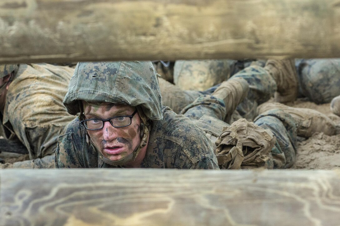 Marine Corps recruit Robbin Anderson low-crawls while going through the combat endurance course at Marine Corps Recruit Depot Parris Island, S.C., May 20, 2017. The course includes a 2.5-mile run with obstacles along the way designed to improve small-unit leadership among recruits. Marine Corps photo by Cpl. Richard Currier