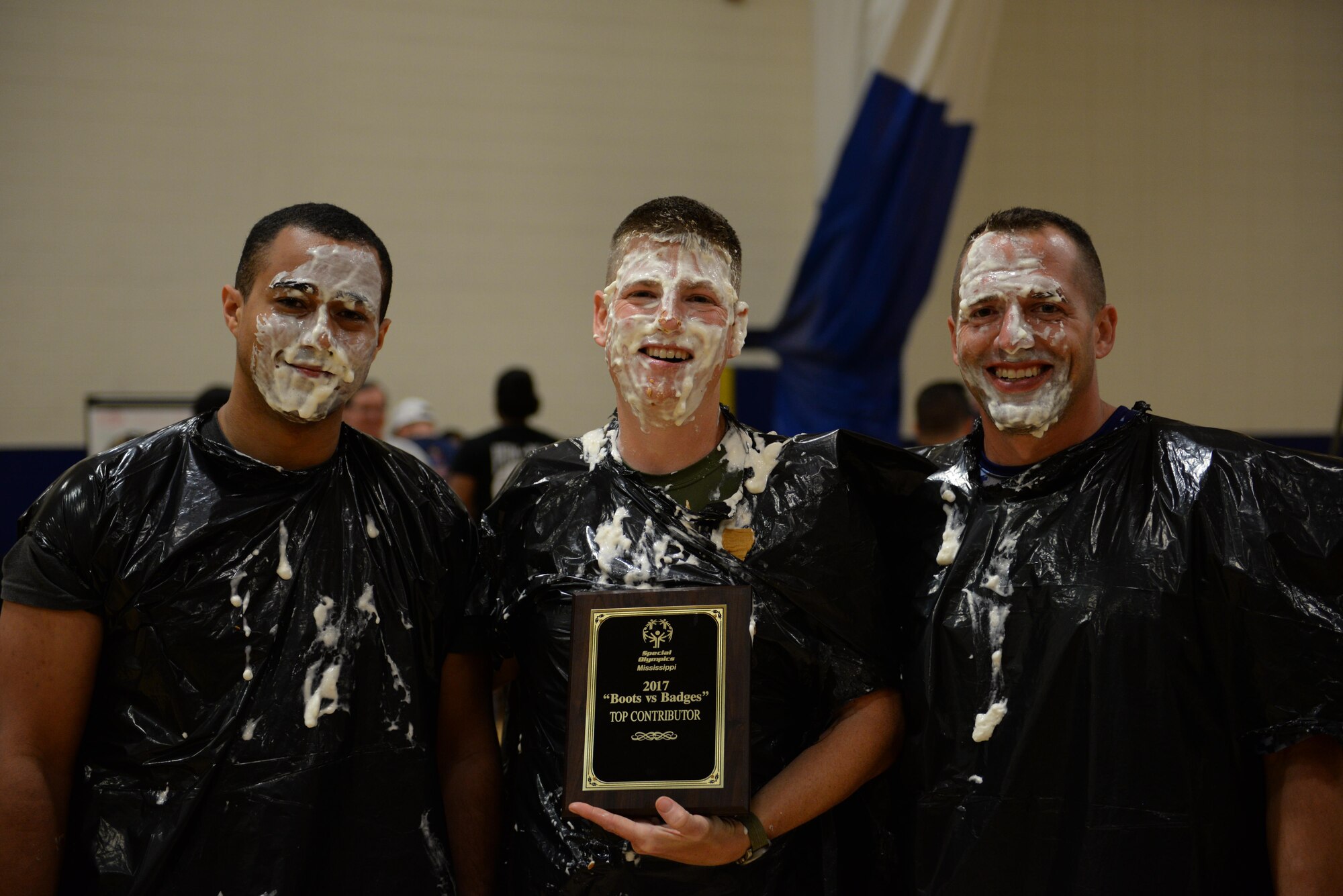 Airmen from the ‘Boots’ team pose for a photo after getting a pie in the face after the Boots vs. Badges volleyball game at the Blake Fitness Center, May 13, 2017, on Keesler Air Force Base, Miss. Keesler Airmen competed against City of Biloxi police officers and firefighters as the starting event for the 2017 Special Olympics Mississippi Summer Games, which will be hosted on base for the 31st year May 19-21. (U.S. Air Force photo by Senior Airman Duncan McElroy)