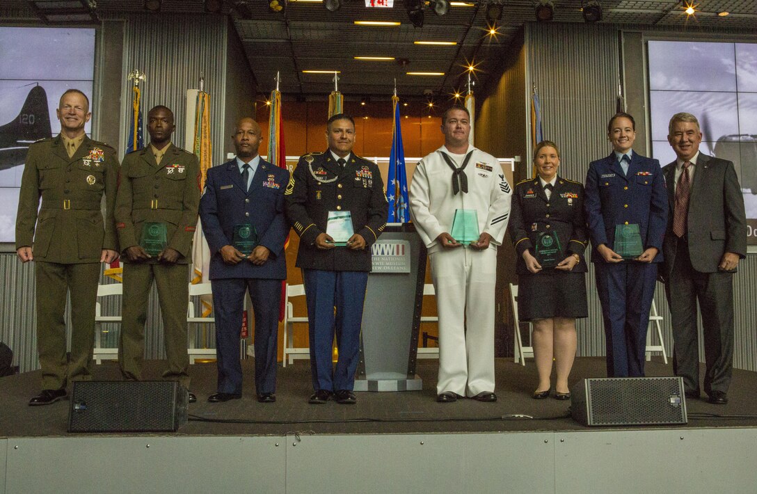 Service members pose for a photo during the Mayor’s Community Service Award at the World War II Museum in New Orleans, May 20, 2017. Sgt. Juvante Butler (second from left), an administrative specialist with 4th Marine Division, Marine Forces Reserve, received the award for his dedication and hard work within the New Orleans community. (U.S. Marine Corps photo by Pfc. Melany Vasquez / Released)