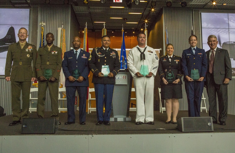 Service members pose for a photo during the Mayor’s Community Service Award at the World War II Museum in New Orleans, May 20, 2017. Sgt. Juvante Butler (second from left), an administrative specialist with 4th Marine Division, Marine Forces Reserve, received the award for his dedication and hard work within the New Orleans community. (U.S. Marine Corps photo by Pfc. Melany Vasquez / Released)