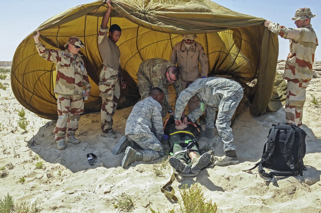 U.S. airmen and French security forces prepare a simulated casualty for transport during a joint crash exercise at an undisclosed location in Southwest Asia, May 16, 2017. The airmen are assigned to the 380th Expeditionary Medical Group medical operations flight. Air Force photo by Staff Sgt. Marjorie A. Bowlden