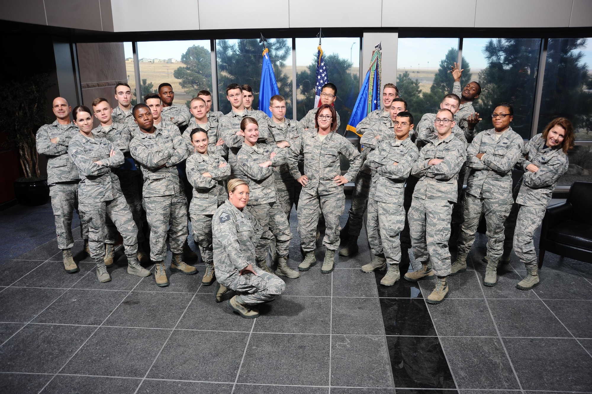 Col. Robyn Slade (right), 50th Space Wing senior individual mobilization augmentee to the commander, poses with a joyful, freshly graduated First-Term Airman’s Course class at Schriever Air Force Base, Colorado, December 9, 2016. Slade attended many FTAC graduations in her time as IMA to the commander. (U.S. Air Force photo/Chris DeWitt) 