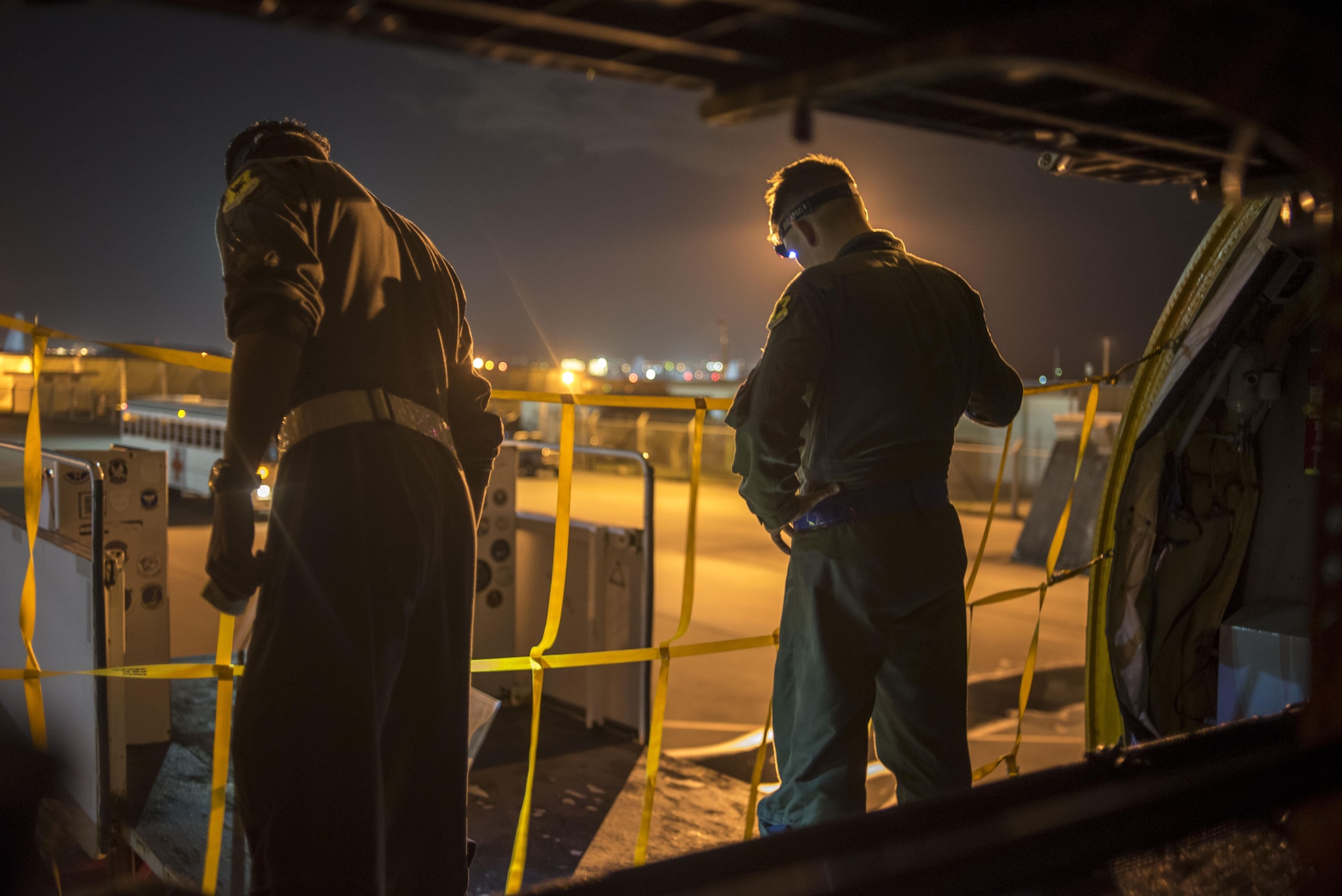 U.S. Air Force Airmen from the 909th Air Refueling Squadron and the 18th Aeromedical Evacuation Squadron guide a staircase into position May 3, 2017, at Kadena Air Base, Japan. While Airmen from each squadron have different mission sets, both of them work together to save lives through aeromedical evacuation. (U.S. Air Force photo by Senior Airman John Linzmeier)