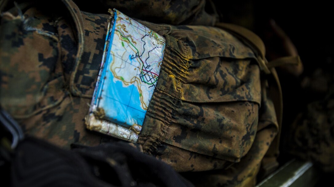Marines use a map to navigate at Jungle Warfare Training Center, Camp Gonsalves, Okinawa, Japan, May 17, 2017. The unit patrolled through the woods, conducted medical evacuations and assaulted enemy villages during their 12-day training iteration. This training prepared them for their upcoming deployment to Thailand and the Philippines in support of the Cooperation Afloat Readiness and Training multilateral exercise. The Marines are with Company K, 3rd Battalion, 8th Marine Regiment and are assigned to 3rd Marine Division, III Marine Expeditionary Force, through the unit deployment program. (U.S. Marine Corps photo by Lance Cpl. Joshua Pinkney)