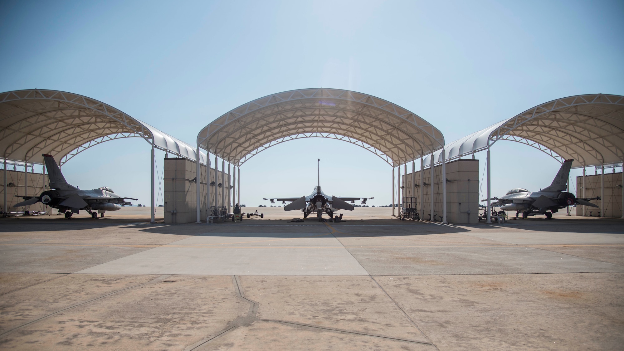 Three F-16 Fighting Falcons from Misawa Air Base, Japan sit under sunshades at Kunsan Air Base, Republic of Korea, May 19, 2017. While deployed to Kunsan, the 14th Fighter Squadron have flown joint offensive counter-air, defensive counter-air and suppression of enemy air defenses – the primary capability at Misawa AB. (U.S. Air Force photo by Senior Airman Brittany A. Chase)
