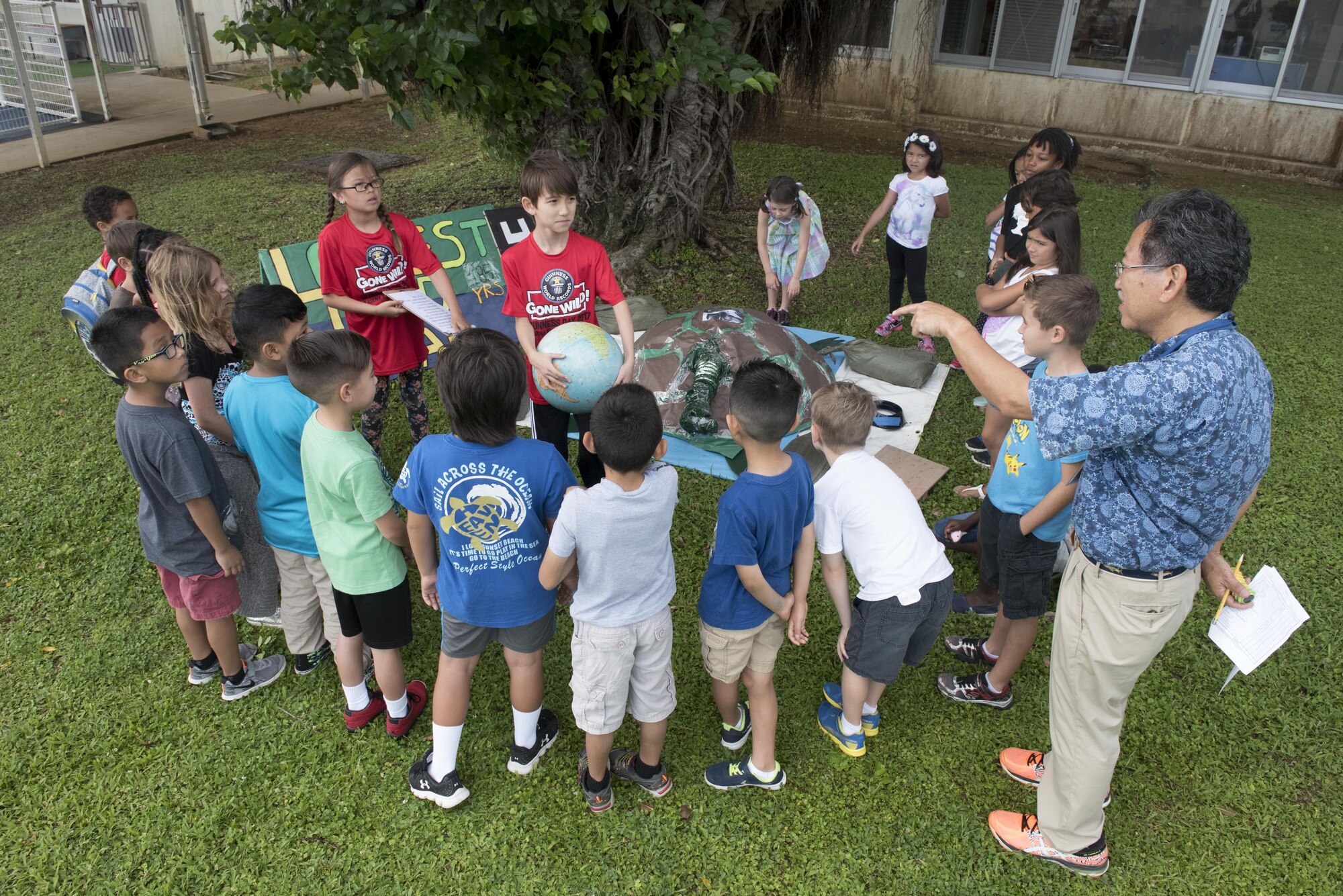 Children from Kadena Elementary School’s English as a Second Language team present a life-sized replica of a giant tortoise to their classmates May 22, 2017, at Kadena Air Base, Japan.  The school’s 60 ESL members worked together with parents and teachers over the course of three weeks to construct props and other stations for the event. (U.S. Air Force photo by Senior Airman John Linzmeier)