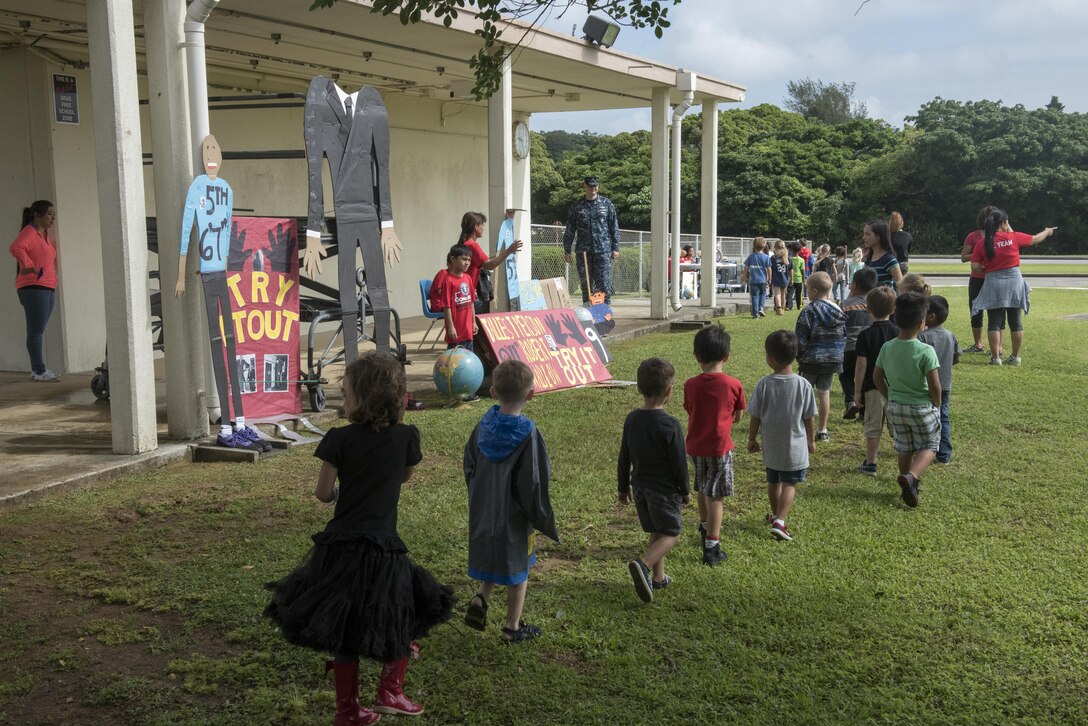 Children from Kadena Elementary School walk from one educational booth to another May 22, 2017, at Kadena Air Base, Japan. The school’s English as a Second Language team presented 12 stations representing Guinness Book of World Records to the whole school. (U.S. Air Force photo by Senior Airman John Linzmeier)