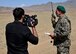 A local Afghan reporter films as an Afghan Air Force member communicates on the ground with an A-29 Super Tucano pilot over radio communications near Logar Province, Afghanistan, May 21, 2017. Train, Advise, Assist Command-Air (TAAC-Air) advisors, held a live-fire training exercise for a class of Afghan Tactical Air Coordinators. Prior to the exercise, advisors from TAAC-Air conducted three weeks of classroom training. The live fire exercise is part of a practical evaluation before Afghan Air Force personnel can graduate as ATACs. (U.S. Air Force photos by Tech. Sgt. Veronica Pierce)