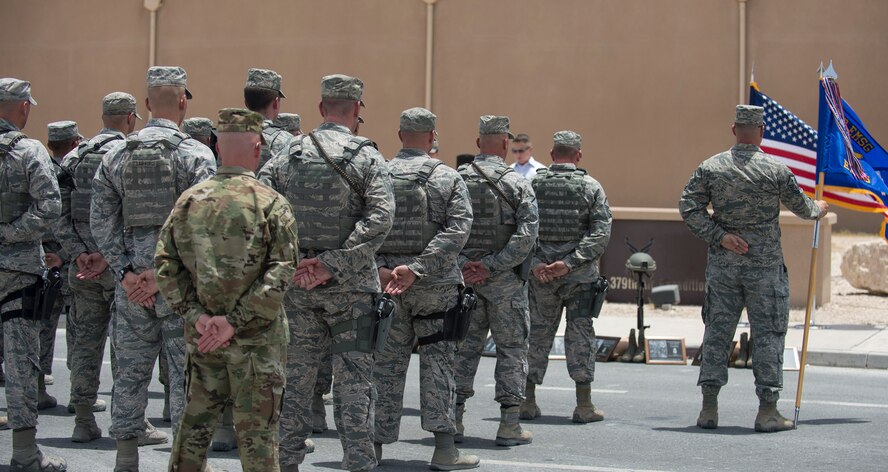 U.S. Air Force airmen with the 379th Expeditionary Security Forces Squadron and 379th Air Expeditionary Wing stand in formation as the names of 12 U.S. Air Force Office of Special Investigations agents are read at Al Udeid Air Base, Qatar, May 19, 2017. The final guardmount ceremony is a tradition where all members of ESFS pay tribute to fallen Security Forces Airmen and U.S. Air Force Office of Special Investigations agents who died in the line of duty by calling out their names as the flight sergeant conducts roll call. (U.S. Air Force photo by Tech. Sgt. Amy M. Lovgren)