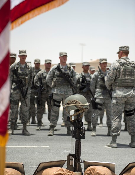 U.S. Air Force Airmen with the 379th Expeditionary Security Forces Squadron stand in formation as names of 14 U.S. Air Force Security Forces members are read at Al Udeid Air Base, Qatar, May 19, 2017. The final guardmount ceremony is a tradition where all members of ESFS pay tribute to fallen Security Forces Airmen and U.S. Air Force Office of Special Investigations agents who died in the line of duty by calling out their names as the flight sergeant conducts roll call. (U.S. Air Force photo by Tech. Sgt. Amy M. Lovgren)