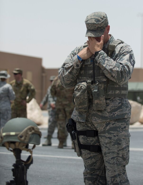 A U.S. Air Force airman with the 379th Expeditionary Security Forces Squadron remembers fallen security forces members at Al Udeid Air Base, Qatar, May 19, 2017. Airman took part in the final guardmount ceremony which is a tradition where all members of ESFS pay tribute to fallen Security Forces Airmen and U.S. Air Force Office of Special Investigations agents who died in the line of duty by calling out their names as the flight sergeant conducts roll call. (U.S. Air Force photo by Tech. Sgt. Amy M. Lovgren)