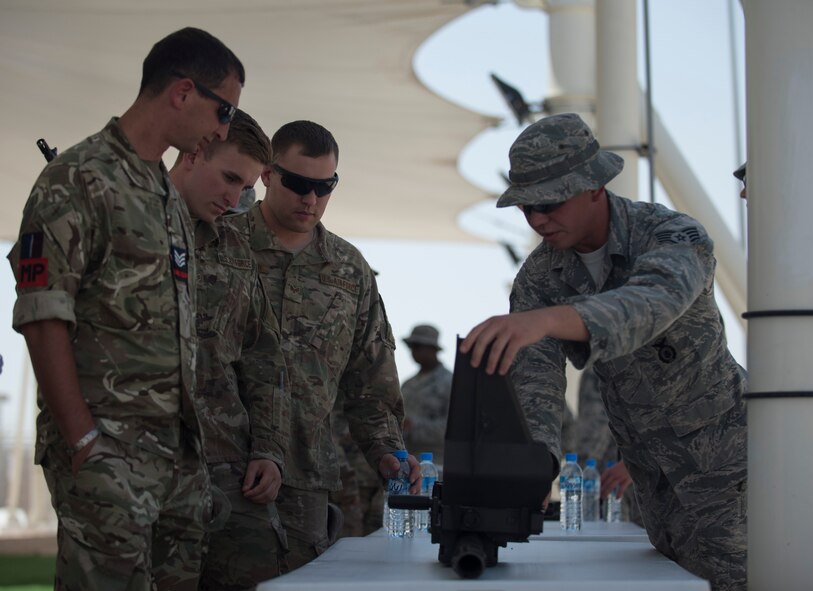 U.S. Air Force Staff Sgt. Cody Albritton, right, a combat arms instructor with the 379th Expeditionary Security Forces Squadron, shows a group of service members the nomenclature of the Mark-19 40 mm grenade machine gun at Al Udeid Air Base, Qatar, May 15, 2017. Airmen from the 379th ESFS organized a week of law enforcement activities to honor fallen civilian police officers, security forces airmen and U.S. Air Force Office of Special Investigations agents who died in the line of duty. (U.S. Air Force photo by Tech. Sgt. Amy M. Lovgren)
