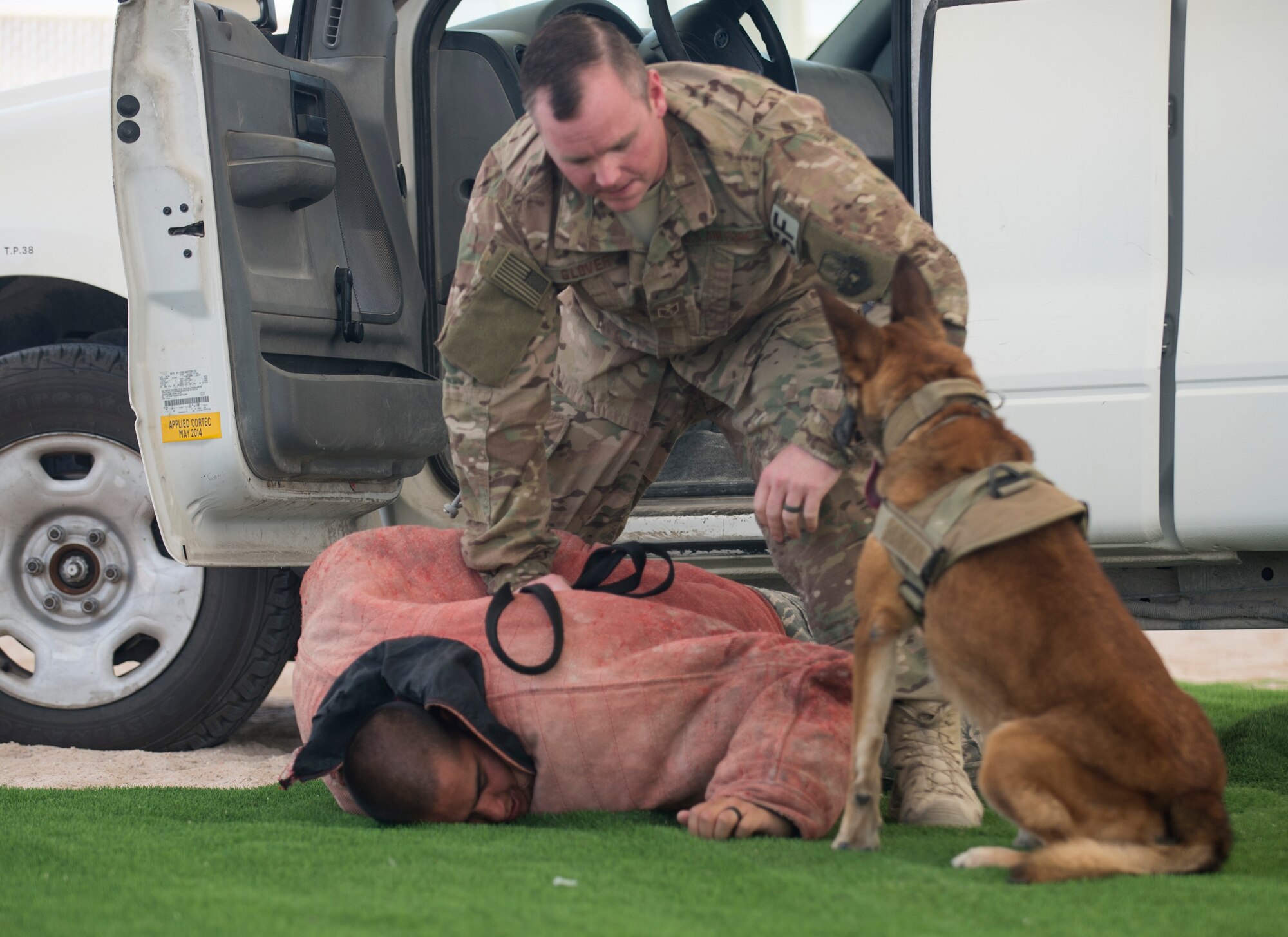 U.S. Air Force Staff Sgt. Timothy Glover, a military working dog handler with the 379th Expeditionary Security Forces Squadron, apprehends a role player after his military working dog Pprada completes a vehicle extraction demonstration at Al Udeid Air Base, Qatar, May 15, 2017. Airmen from the 379th ESFS organized a week of law enforcement activities to honor fallen civilian police officers, security forces airmen and U.S. Air Force Office of Special Investigations agents who died in the line of duty. (U.S. Air Force photo by Tech. Sgt. Amy M. Lovgren)