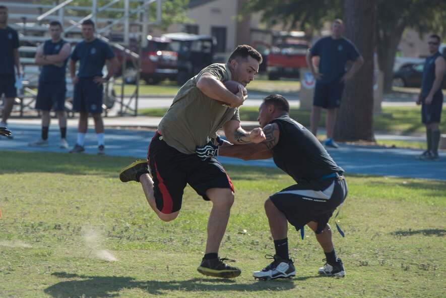 An Airman from the 822d Base Defense Squadron breaks a tackle from a 23d Security Forces Squadron member during Police Week’s football tournament, May 18, 2017, at Moody Air Force Base, Ga. Police Week is designed to honor the legacies fallen officers, both civilian and military, have left behind, but it also gives various sections within the law enforcement community an opportunity to train together in friendly competitions. (U.S. Air Force photo by Senior Airman Greg Nash) 
