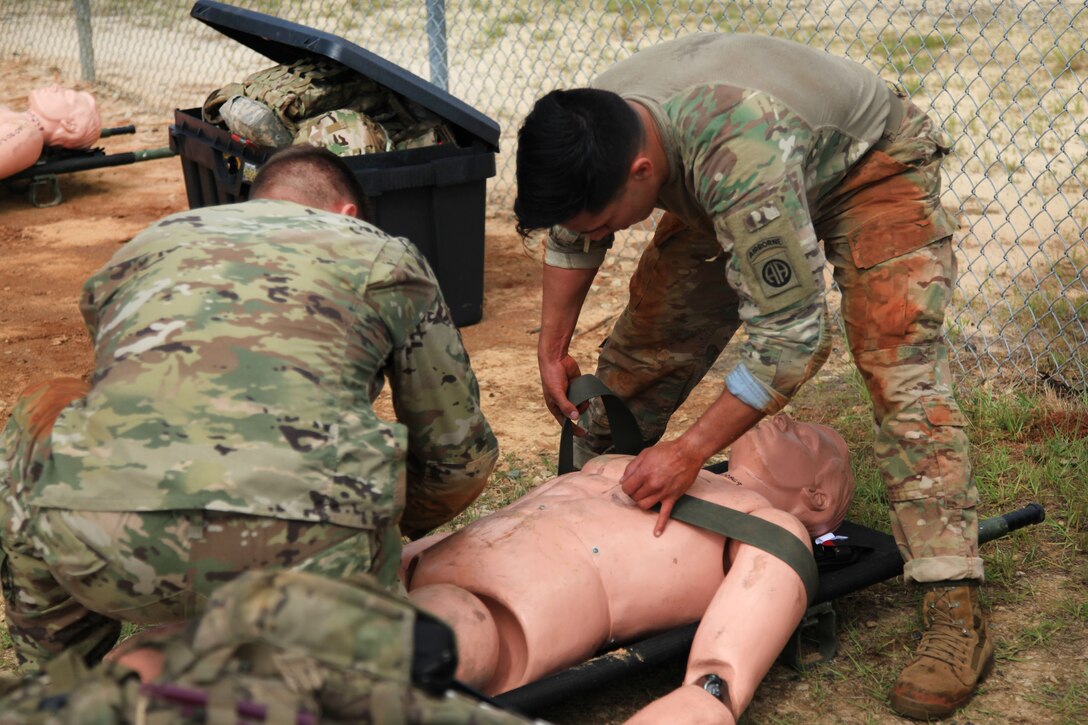Paratroopers provide medical aid and strap a mannequin to a stretcher as part of the Best Squad Competition during All American Week at Fort Bragg, N.C., May 22, 2017. Army photo by Staff Sgt. Amber Stephens