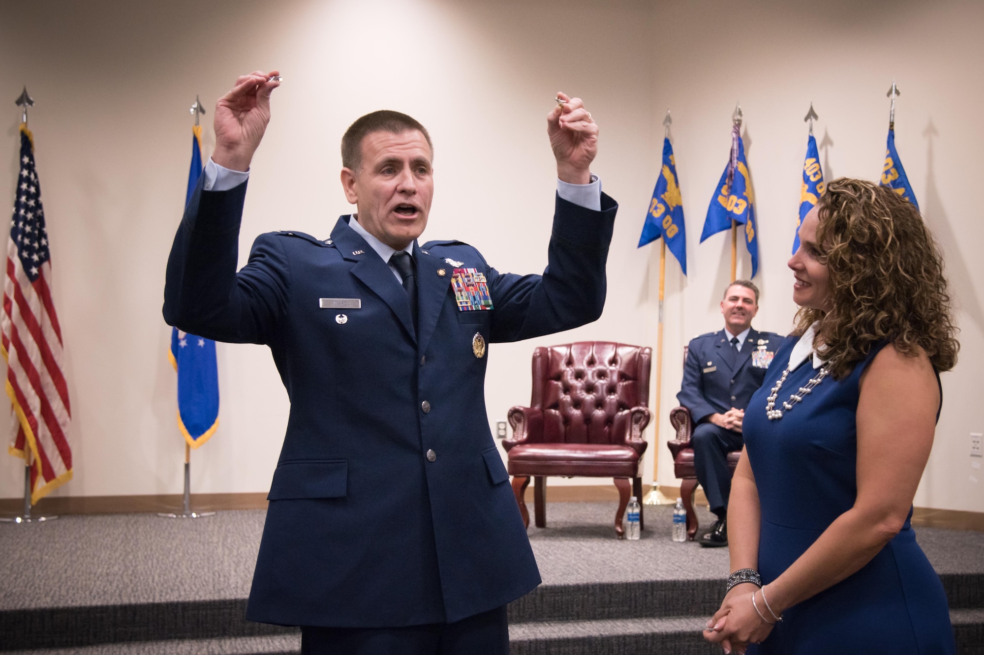 Retired Col. Howard Ward Jr. gives two general officer stars to Kathy May, wife of Col. Brian May, 403rd Operations Group commander during May's promotion ceremony March 4, 2017 at Keesler Air Force Base, Mississippi.  (U.S. Air Force photo/Staff Sgt. Heather Heiney)