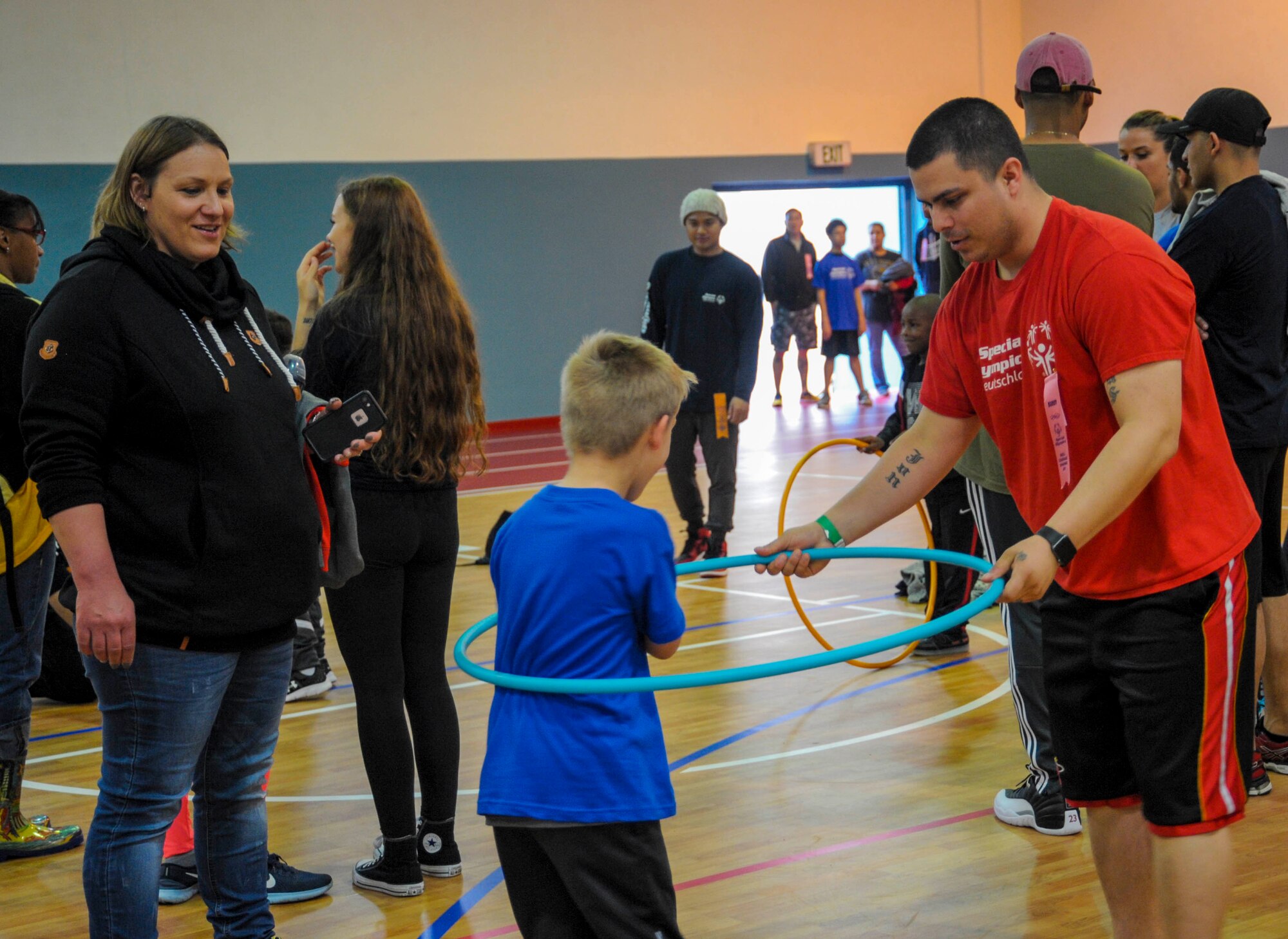 U.S. Air Force Tech. Sgt. Jonathan Garrett, 86th Vehicle Readiness Squadron resource advisor, helps Kai, a special Olympian, practice for the hula hoop event on Ramstein Air Base, Germany, May 19, 2017. The hula hoop event was just one of several competitions held during the 2017 Spring Kaiserslautern Military Community Special Olympics. More than 70 students competed in events including hula hoop, tug-of-war, basketball skills, volleyball, and more throughout the day. (U.S. Air Force photo by Staff Sgt. Timothy Moore)