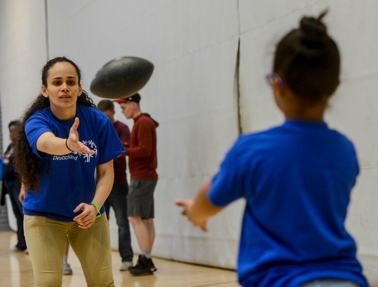 U.S. Army Sgt. Brenda Contreras, 5th Quartermaster, 21st Special Troops Battalion, 21st Theater Sustainment Command, tosses a football to Aviella, a special Olympian, during a break on Ramstein Air Base, Germany, May 19, 2017. Aviella and the other students competing in the 2017 Spring Kaiserslautern Military Community Special Olympics received a volunteer to accompany them as a “buddy” throughout the day. (U.S. Air Force photo by Staff Sgt. Timothy Moore)