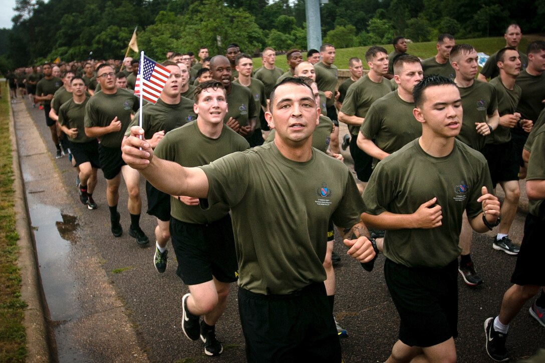 A paratrooper waves a U.S. flag while running in formation during the All American Week division run on Longstreet Road at Fort Bragg, N.C., May 22, 2017. Army photo by Pfc. Hubert D. Delany