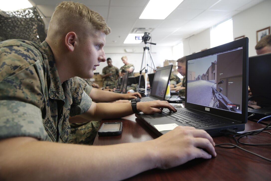 A Marine equipped with an M249 light machine gun within a virtual training program engages the enemy team during a Spartan Tactical Games competition at Camp Lejeune, N.C., May 16, 2017. The Marines participated in a squad versus squad virtual training exercise to improve their tactics and maneuvers in a controlled environment. The Marines are with 2nd Battalion, 6th Marine Regiment. (U.S. Marine Photo by Lance Cpl Leynard Kyle Plazo)