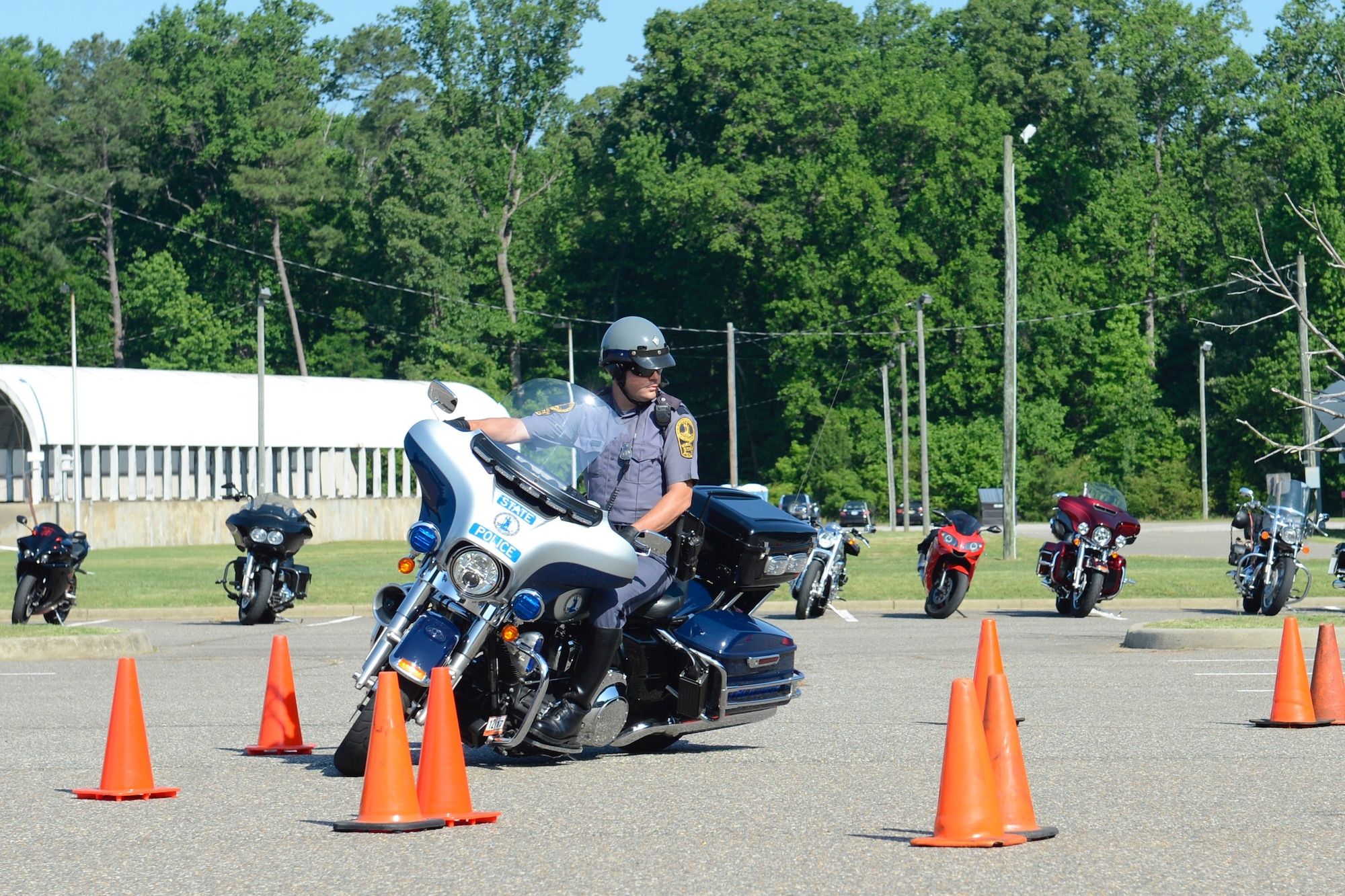 Virginia State Police Trooper J.A. Vance, Motorcycle Unit member, demonstrates motorcycle handling skills through a cone course at the Armed Forces Motorcycle Safety event and ride at Joint Base Langley-Eustis, Va., May 19, 2017. Observers were given the chance to test out their motorcycle handling skills after the demonstration. (U.S. Air Force photo/Airman 1st Class Kaylee Dubois)