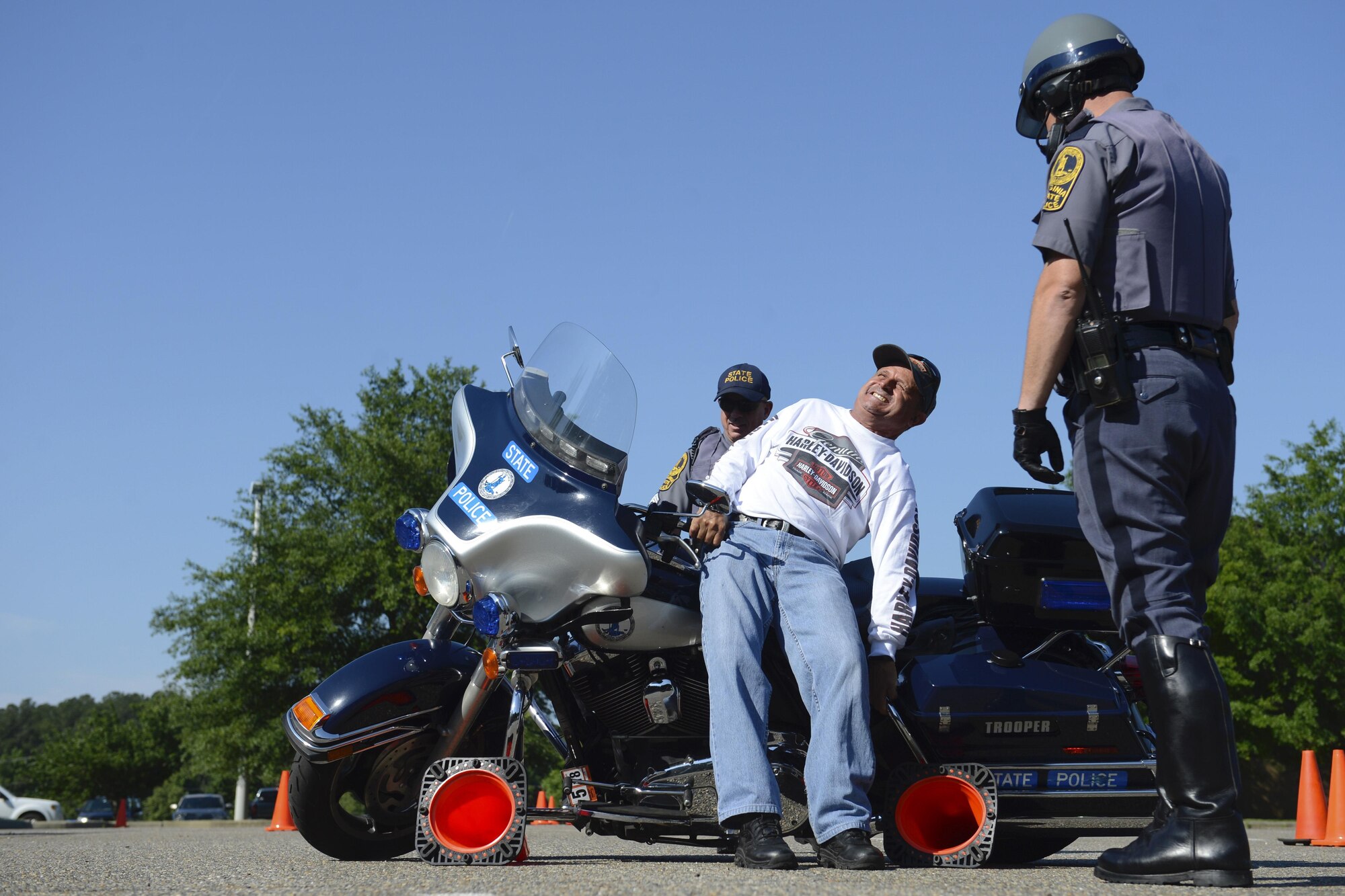 Retired U.S. Army Master Sgt. Ruben Nieves, Armed Forces Motorcycle Safety event and ride participant, uses tips from the Virginia State Police Motorcycle Unit to pick up a downed motorcycle properly at Joint Base Langley-Eustis, Va., May 19, 2017. The police unit offered safety tips and reminded the riders of the rules of the road. (U.S. Air Force photo/Airman 1st Class Kaylee Dubois)
