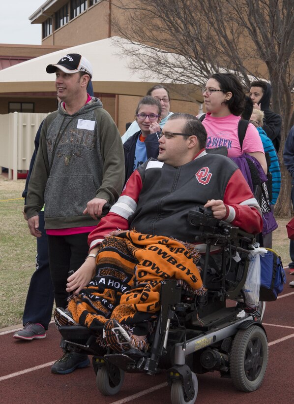 Special Olympians and their families walk during the Parade of Athletes March 22 in the Area 6 Special Olympics Track and Field Meet at Vance Air Force Base. More than 100 volunteers from the community and the base supported several hundred athletes. 