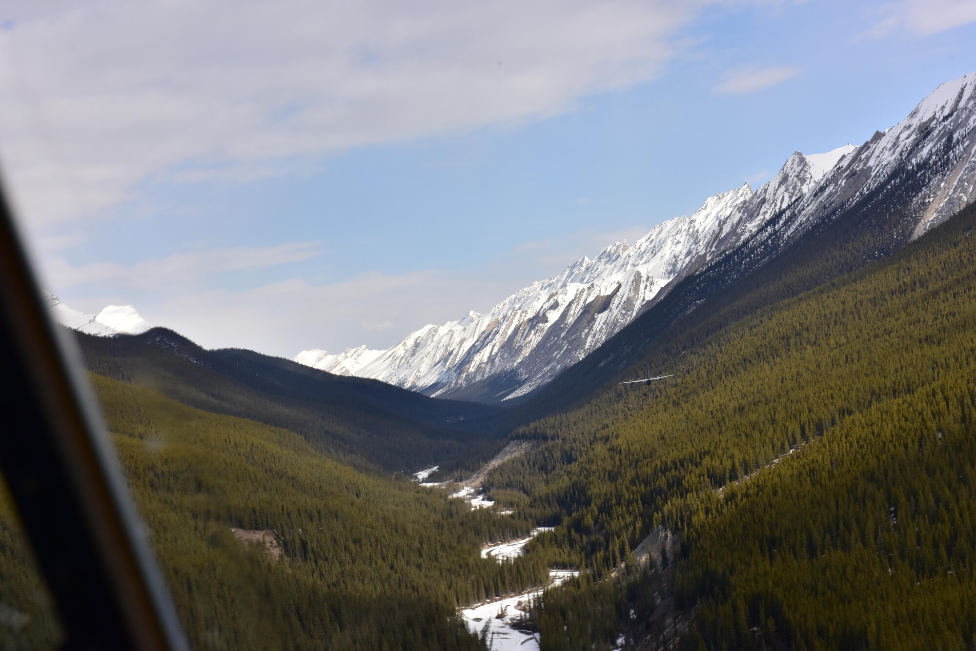 A Royal Canadian air force C-130J flys in formation with a U.S. Air Force C-130J from the 41st Airlift Squadron through the Canadian Rockies demonstrating low altitude high terrain evasion techniques April 20, 2017 in Alberta, Canada. This is the first time American forces have participated in the Canadian Fanatic Pegasus exercise which establishes air and ground forces in unfamiliar terrain to work on communication and rapid deployment of those resources.  
(U.S. Air Force photo by Staff Sgt. Jeremy McGuffin)
