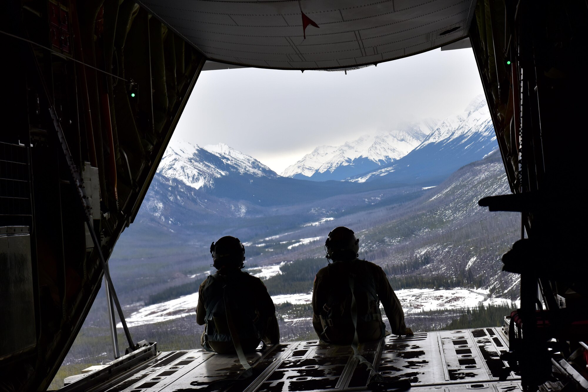 U.S. Air Force Tech. Sgt. Ryan Maxey (right) and Airman 1st Class Tyler Wilson, 41st Airlift Squadron Loadmasters, watch out of the back of their C-130J after a simulated cargo drop while navigating through the Canadian Rockies during the Fanatic Pegasus exercise with Royal Canadian air forces in Alberta, Canada, April 20, 2017. This is the first time American forces have participated in this exercise which establishes air and ground forces in unfamiliar terrain to work on communication and rapid deployment of those resources.
(U.S. Air Force photo by Staff Sgt. Jeremy McGuffin)