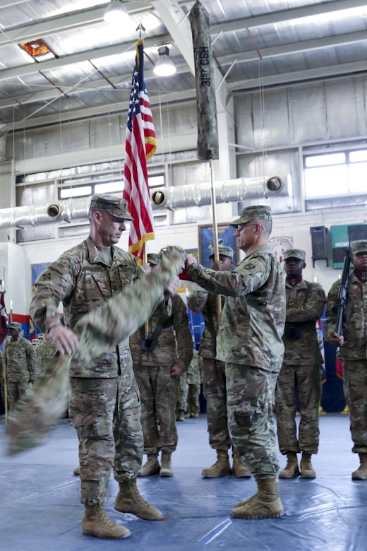 Col. Bruce Syvinski (right), the commander of the 86th Combat Support Hospital, and Command Sgt. Maj. Daryl Forsythe, the command sergeant major for the 86th CSH, uncases the unit’s colors, during the transfer of authority ceremony, in the Zone 1 Fitness Center, Camp Arifjan, Kuwait, May 5. The ceremony marked the last deployment for the 86th CSH, as it will re-designate into a field hospital when it returns from this rotation. (U.S. Army photo by Sgt. Bethany Huff, ARCENT Public Affairs)